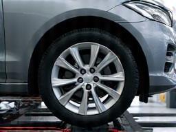 Car wheels being measured on a wheel alignment machine.